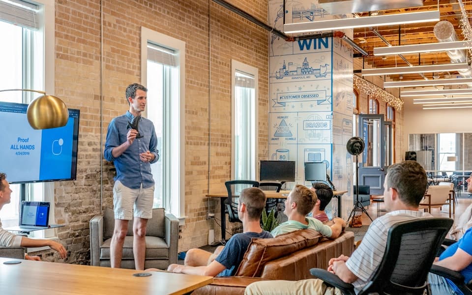 All-Hands-Präsentation im ClarioPay-Team: Gründer spricht vor Mitarbeitern im Loft-Büro